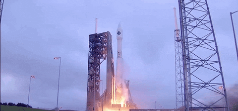 A rocket lifting off a launch pad under an overcast sky, real footage.